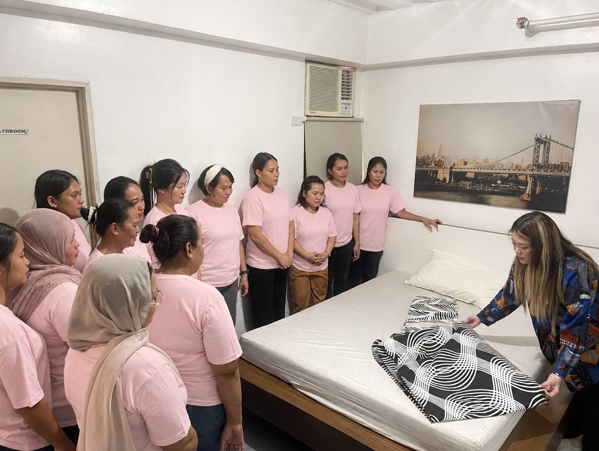 Helpers practising bed-making during training